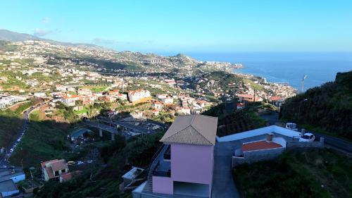 a view of a city from a hill with the ocean at Peaceful Valley house in Câmara de Lobos