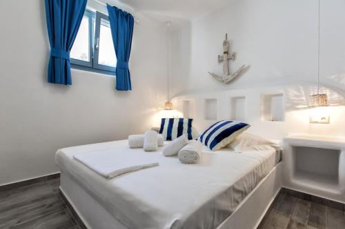 a bedroom with a bed with blue curtains and a sink at Casa Perla in Mikri Vigla