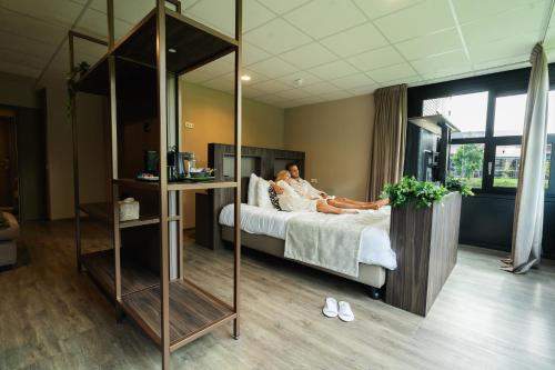 a couple laying on a bed in a hotel room at Hotel WICC in Wageningen