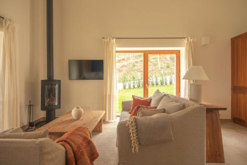 a living room with a couch and a fireplace at Cabaña Quieva 07 in Rubalcaba