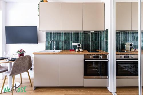 une cuisine avec des armoires blanches et un évier dans l'établissement Casa So Nice, à Nice