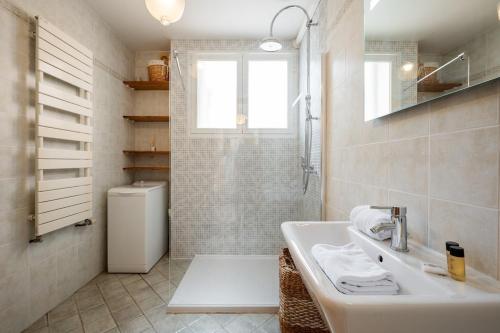 une salle de bain blanche avec un lavabo et des toilettes dans l'établissement Val de Menton, Charmant 3 pièces atypique, jardin et terrasse à 7 minutes à pied du centre ville, à Menton
