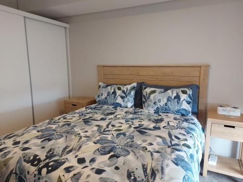 a bedroom with a bed with a blue and white comforter at 202 Mossel Cove in Mossel Bay