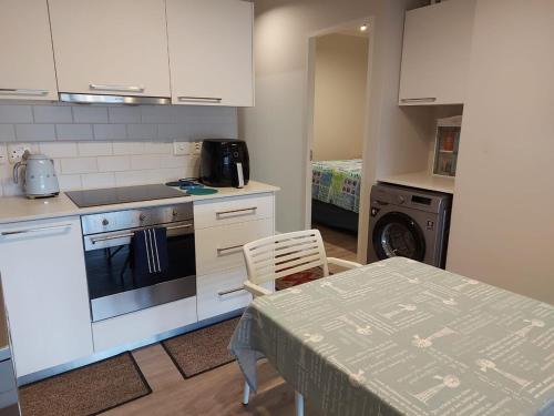 a kitchen with a table and a stove and a laundry room at 202 Mossel Cove in Mossel Bay