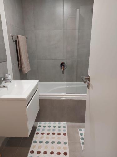 a bathroom with a sink and a bath tub at 202 Mossel Cove in Mossel Bay