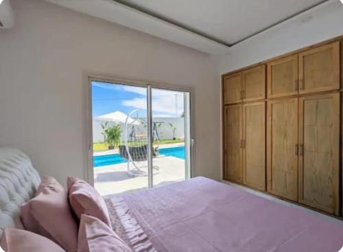 a bedroom with a bed and a sliding glass door at Wonderful villa rental with swimming pool in Arkou