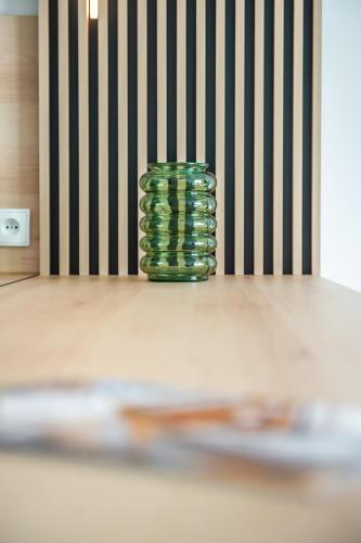 a green vase sitting on top of a table at Apartament Korfantego 9 in Gliwice