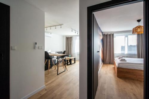 a bedroom with a bed and a room with a table at Apartament Korfantego 9 in Gliwice