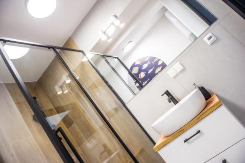 a bathroom with a sink and a staircase at Apartament Korfantego 9 in Gliwice