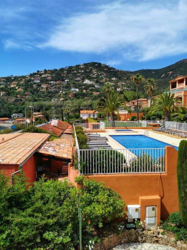 une maison avec une piscine et une montagne dans l'établissement Appartement avec vue sur le port de la Figueirette, à Théoule-sur-Mer