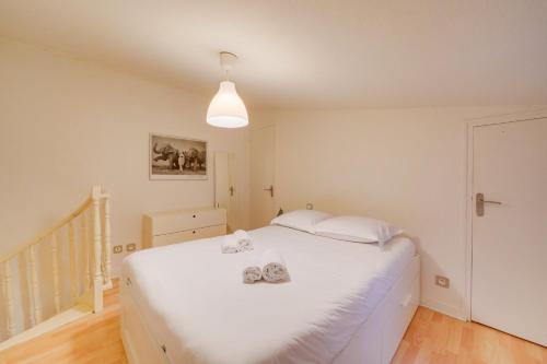 une chambre avec un grand lit blanc avec des serviettes dessus dans l'établissement Bel appartement Bordeaux Tourny, à Bordeaux