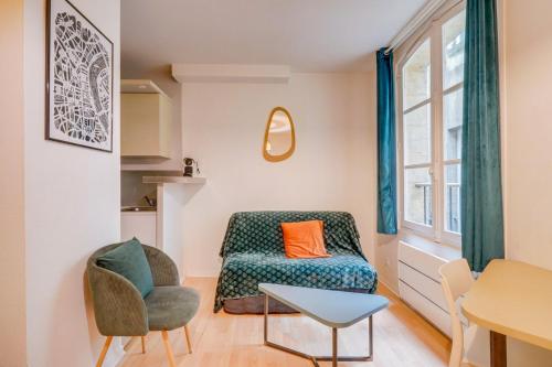 un salon avec un canapé et une chaise dans l'établissement Bel appartement Bordeaux Tourny, à Bordeaux
