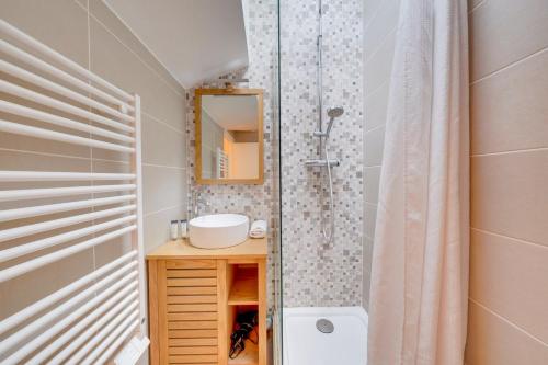 une salle de bain avec une douche, un lavabo et un miroir dans l'établissement Bel appartement Bordeaux Tourny, à Bordeaux