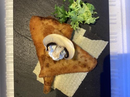 a plate with a mushroom on a piece of pizza at Goiko-Benta Ostatua in Oñate