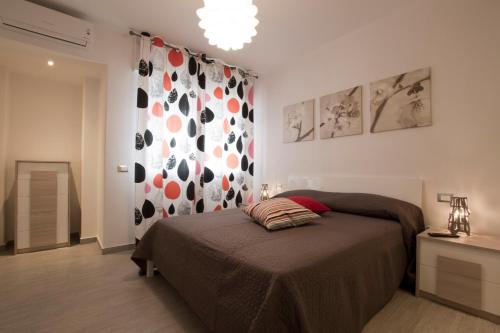 a bedroom with a bed and a wall with paintings at Excelsior in Piombino