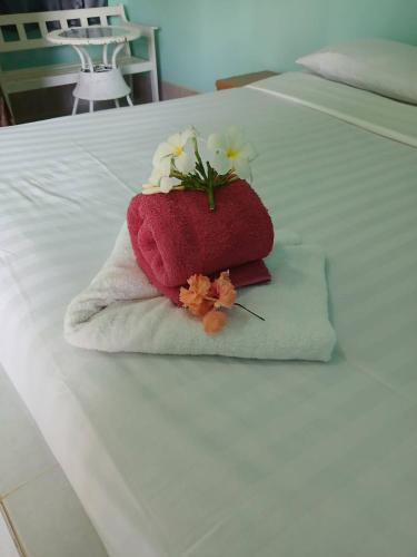 un asciugamano con dei fiori sopra su un letto di Stella Resort Khanom a Khanom