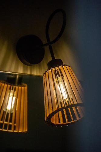 two lights are hanging from a wall at Apartament Korfantego 9 in Gliwice