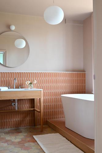 a bathroom with a tub and a sink at Hôtel les Prés in Saint-Hilaire-le-Châtel
