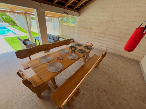 un tavolo in legno con sedie in una camera con piscina di Stone & Sun Retreat with Private Pool a Rupalj