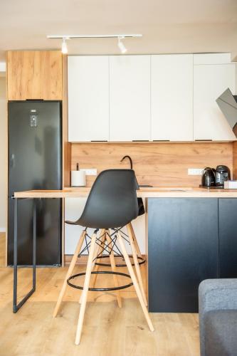 a black chair sitting at a desk in a kitchen at Apartament Korfantego 9 in Gliwice