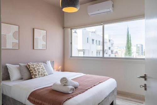 a bedroom with a large bed with a window at Dune - 1 Bedroom Retreat W Balcony in Mackenzie in Larnaka