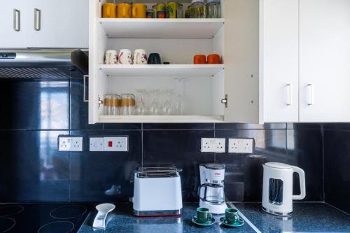 a kitchen with white cabinets and a counter top at Dune - 1 Bedroom Retreat W Balcony in Mackenzie in Larnaka