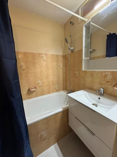 une salle de bain avec un lavabo et une baignoire et un lavabo dans l'établissement Bel T2 in St Lary - Résidence Lustou, à Saint-Lary-Soulan