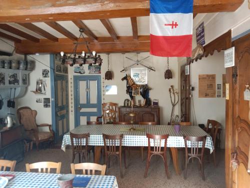une salle à manger avec une table et un drapeau sur le mur dans l'établissement Chambres d'hotes la Fromagerie du Relais Postal Royal, à Colombey-les-Deux-Églises