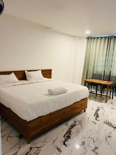 a bedroom with a large bed and a table at MidTown Residency in Mannārakkāt