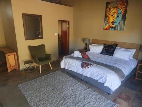 a bedroom with a large bed and a chair at The Lions Foundation Rescue & Conservation Centre at Schrikkloof in Warmbaths