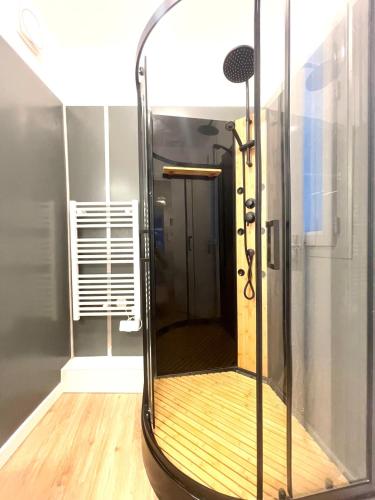 une douche avec une porte vitrée dans une pièce dans l'établissement Jungle Room - Atypique - Spacieux - WIFI - TV 4K - Vue Sur Ville - Confort, à Rouen