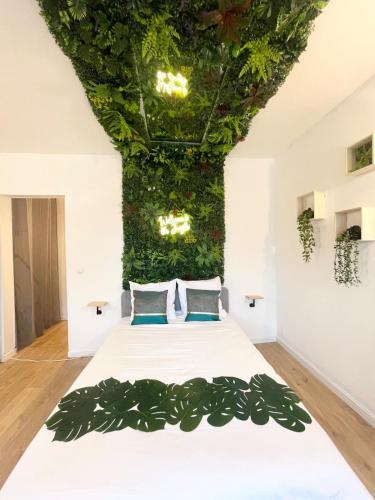- une chambre avec un lit orné d'un mur de plantes dans l'établissement Jungle Room - Atypique - Spacieux - WIFI - TV 4K - Vue Sur Ville - Confort, à Rouen