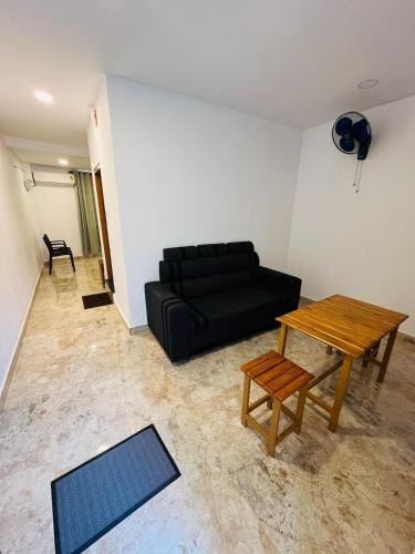 a living room with a black couch and a table at MidTown Residency in Mannārakkāt