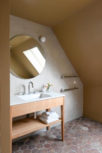 a bathroom with a sink and a mirror at Hôtel les Prés in Saint-Hilaire-le-Châtel