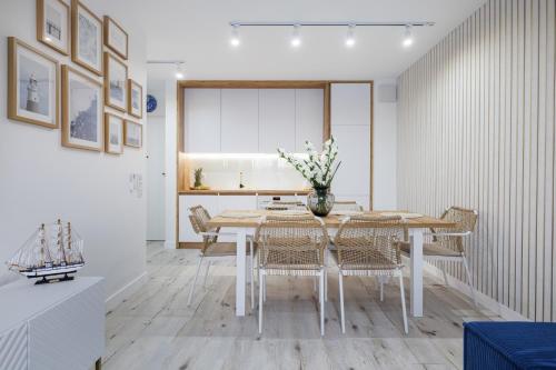 a dining room with a white table and chairs at Rezydencja Merwede Aparthotel - My Rest in Gdańsk