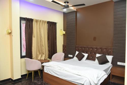 1 dormitorio con 1 cama y 2 sillas rosas en Triveni Hotel And Restaurant, en Barsāna