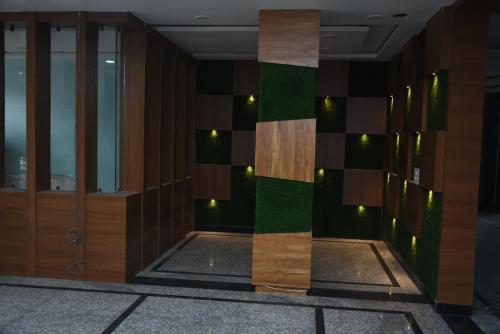 un vestíbulo de un edificio con madera y verde en Triveni Hotel And Restaurant, en Barsāna