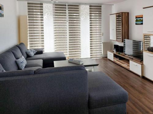 a living room with a blue couch and a tv at Dorow Ferienwohnung in Redewisch