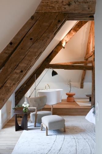 a bathroom with a bath tub in the attic at Hôtel les Prés in Saint-Hilaire-le-Châtel