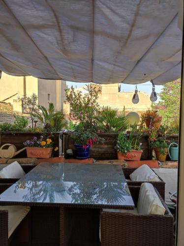 une table et des chaises sous une tente avec des plantes en pot dans l'établissement T3 avec Terrasse Wi-Fi - Clim Avignon intramuros, à Avignon