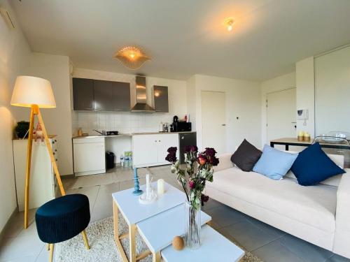 - un salon avec un canapé blanc et une table fleurie dans l'établissement Casa Moderna, à Angers