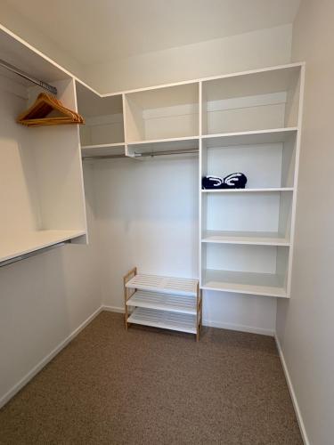 un vestidor con estanterías blancas y un banco en Mountain Abode Studio, en Methven