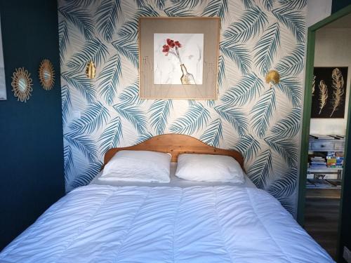 - une chambre avec un lit aux motifs bleus et blancs dans l'établissement Clair de lune, à Murat-le-Quaire