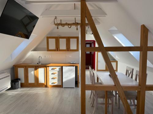 a kitchen and dining room in a loft with a staircase at Beck's Borveranda Palkonya in Palkonya