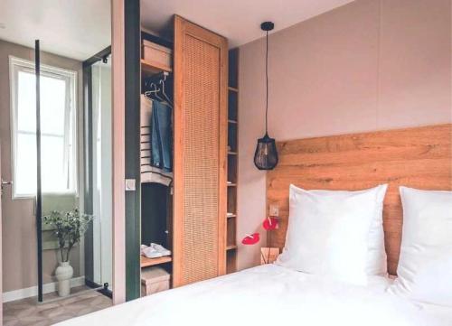 une chambre avec un grand lit blanc et une fenêtre dans l'établissement Camping - Piscine - ccagefg, à Portiragnes