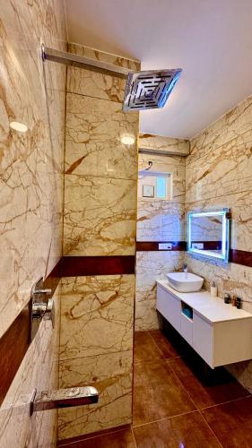 a bathroom with a sink and a shower at adiMOUNT-Kumaon Eco Resort in Dwārāhāt