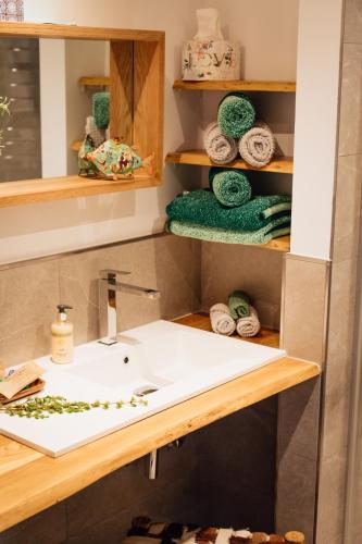 a bathroom with a sink and towels on shelves at Alt Monjoie in Roetgen