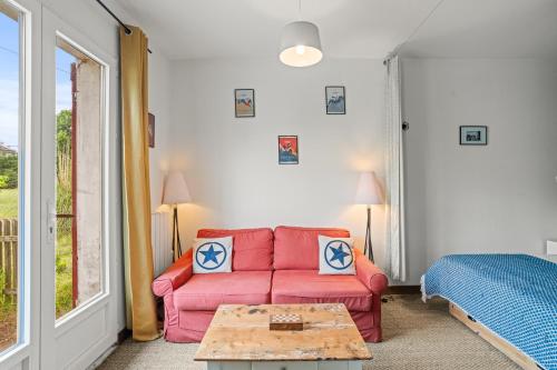 un salon avec un canapé rouge et une table dans l'établissement D&D, La maison des écureuils, à Lesperon