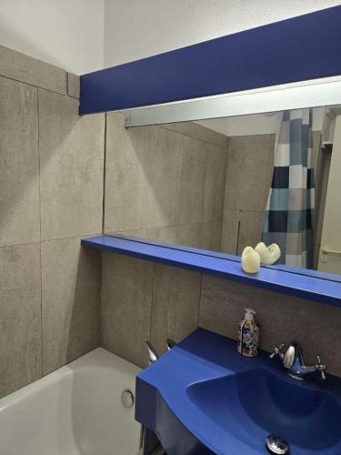 une salle de bain avec un lavabo bleu et un miroir dans l'établissement Perle turquoise, à Saint-Raphaël
