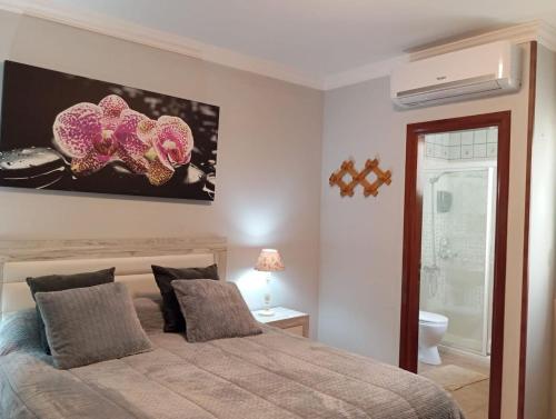 a bedroom with a bed and a painting on the wall at Playa de Mogn Alysio 8 in Puerto de Mogán